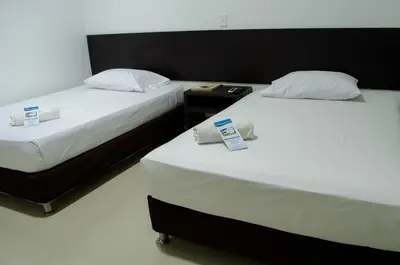 two beds sitting next to each other in a room at Hotel Las Olas Mamonal in Cartagena de Indias