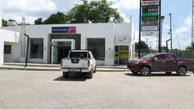 two trucks parked in front of a gas station at Hotel las Olas Malambo in Malambo