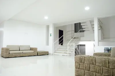 a living room with a couch and a staircase at Hotel las Olas Malambo in Malambo