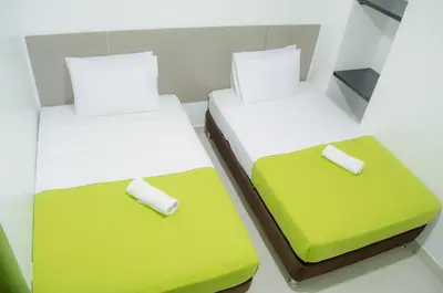 two beds in a room with green and white at Hotel las Olas Malambo in Malambo