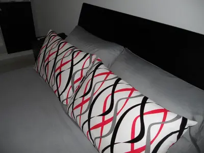 a bed with two red and white pillows on it at Hotel Cosmos Sincelejo in Sincelejo