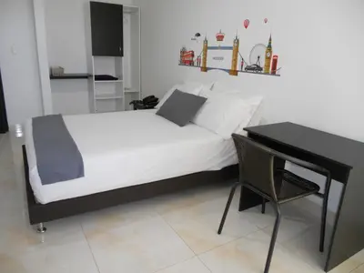 a bed in a room with a desk and a bed sidx sidx sidx at Hotel Cosmos Sincelejo in Sincelejo