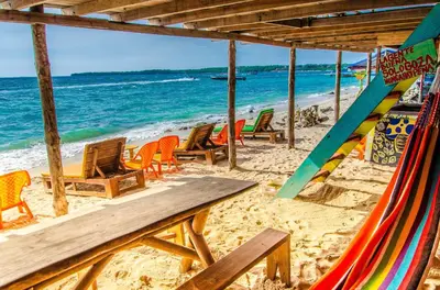 a beach with a bunch of chairs and the ocean at Nuestros Tres Tesoros II in Playa Blanca