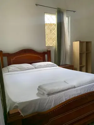 a bedroom with a bed with white sheets and a window at Hostal Santa Clara in San Antero