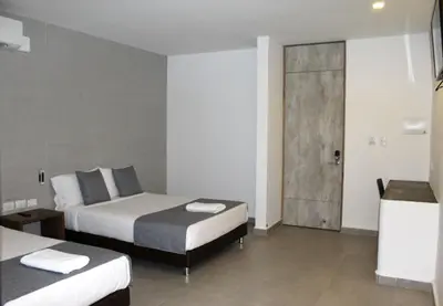 a bedroom with two beds and a sliding glass door at Hotel Hausen in Lorica