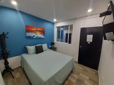 a bedroom with a bed and a blue wall at Hotel Sunset Beach in Cartagena de Indias