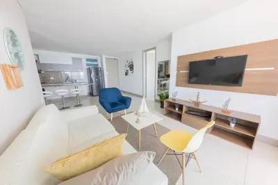 a living room with a white couch and a tv at Edificio Palmetto Beach Apto 1702 in Cartagena de Indias