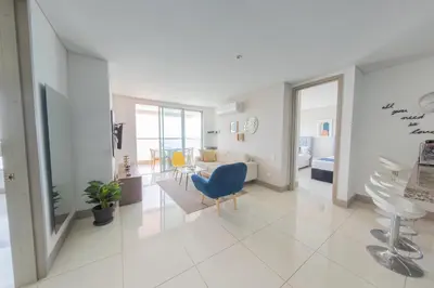 a living room with a blue chair and a table at Edificio Palmetto Beach Apto 1702 in Cartagena de Indias