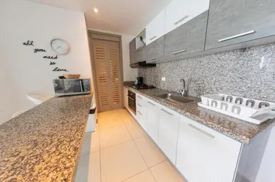 a kitchen with white cabinets and granite counter tops at Edificio Palmetto Beach Apto 1702 in Cartagena de Indias