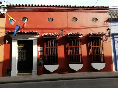 an orange building with black barred windows on a street at Casa Colonial Serrezuela in Cartagena de Indias