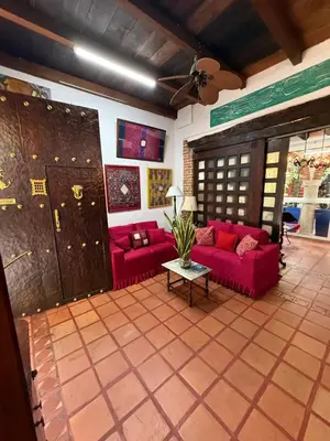 a living room with red couches and a table at Casa Colonial Serrezuela in Cartagena de Indias
