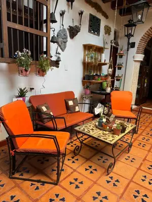a room with orange chairs and a coffee table at Casa Colonial Serrezuela in Cartagena de Indias