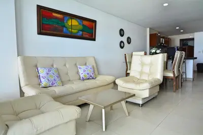 a living room with two white couches and a table at Torres del Lago Apartamentos in Cartagena de Indias