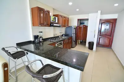 a kitchen with wooden cabinets and a counter top at Torres del Lago Apartamentos in Cartagena de Indias