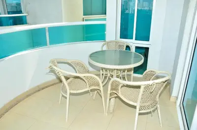 a glass table and chairs on a balcony at Torres del Lago Apartamentos in Cartagena de Indias
