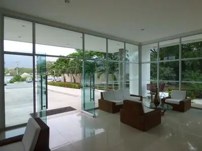 a living room filled with furniture and glass windows at Costa Azul Suites 401 in Santa Marta
