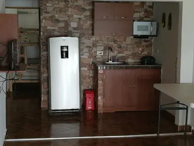 a white refrigerator in a kitchen with a brick wall at Casa Madrigueña in Rincón