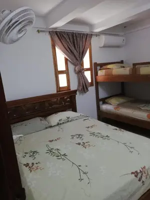 a bedroom with a bed and a window and a fan at Casa Madrigueña in Rincón