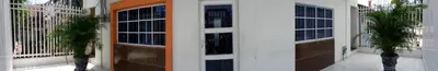 two doors of a building with a palm tree at Hotel Torres del Parque No3 in Barranquilla