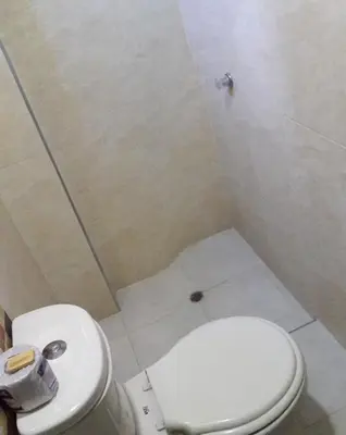 a bathroom with a white toilet and a sink at Hotel Torres del Parque No3 in Barranquilla