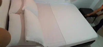 a white couch with a piece of paper on it at Hotel Torres del Parque No3 in Barranquilla