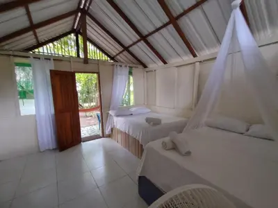 a room with two beds and a window and a room with two beds at Eco Hotel Campo Verde in Isla Grande