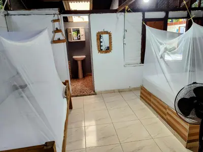 a bathroom with white walls and a tiled floor at Eco Hotel Campo Verde in Isla Grande