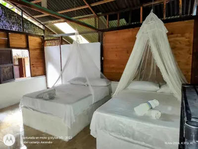 two beds with mosquito nets in a room at Eco Hotel Campo Verde in Isla Grande