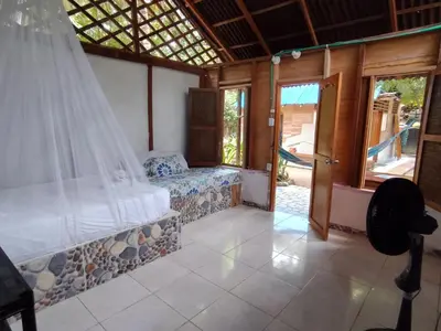 a bedroom with a bed with a mosquito net at Eco Hotel Campo Verde in Isla Grande