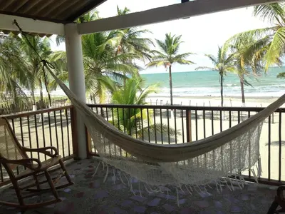 a hammock on a balcony overlooking the beach at Hotel Mar del Viento in San Bernardo del Viento