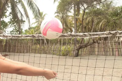 a woman hitting a volley ball on a tennis court at Hotel Mar del Viento in San Bernardo del Viento