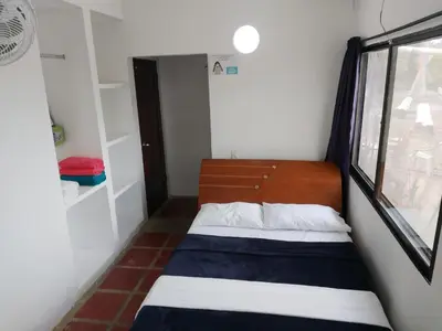 a small bedroom with a bed and a window at Hotel Mar del Viento in San Bernardo del Viento