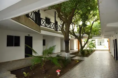 a courtyard of a building with a tree and plants at Hotel El Emigrante in Puerto Colombia