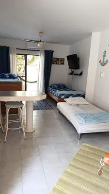 a room with two beds and a table and a tv at Edificio Mar de Leva in Santa Marta