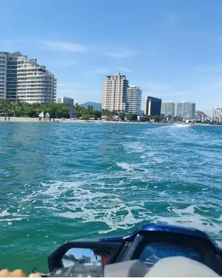 a boat in the water with a city in the background at Edificio Mar de Leva in Santa Marta