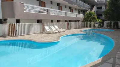 a large swimming pool with two chairs and a building at Edificio Mar de Leva in Santa Marta