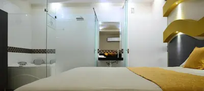 a bedroom with a bed and a glass shower at Hotel Diamante Real Cienaga in Ciénaga