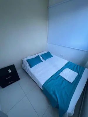 a bedroom with a bed with blue sheets and blue pillows at Cabanas Villa Antonella Covenas in Coveñas