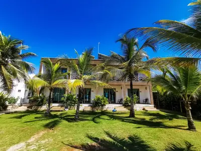 a house with palm trees in front of it at Hotel Camino Verde in Tolú