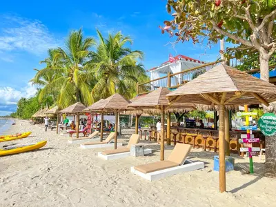a group of umbrellas and chairs on a beach at Hotel Camino Verde in Tolú
