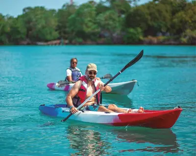 two people kayaking in the water on a lake at Hotel Islabela Islas Del Rosario in Isla Grande