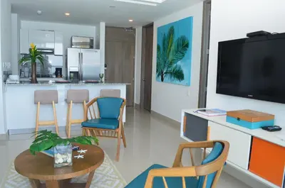 a living room with a kitchen and a table with chairs at Namaste Alojamientos Luxury Cartagena in Cartagena de Indias