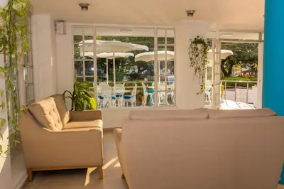 a living room with two chairs and a window at Hotel Coral Reef Cartagena in Cartagena de Indias