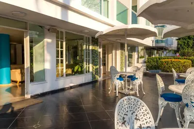 a patio with tables and chairs in a building at Hotel Coral Reef Cartagena in Cartagena de Indias