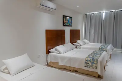 a hotel room with two beds and a window at Hotel Coral Reef Cartagena in Cartagena de Indias