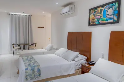 a hotel room with two beds and a tv at Hotel Coral Reef Cartagena in Cartagena de Indias