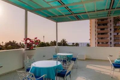a patio with tables and chairs on a balcony at Hotel Coral Reef Cartagena in Cartagena de Indias