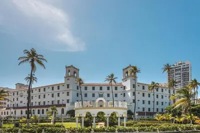 a large white building with palm trees in front of it at Hotel Caribe by Faranda Grand, a member of Radisson Individuals in Cartagena de Indias