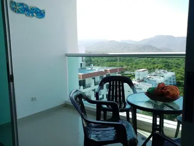 a table and chairs on a balcony with a view at Costa Azul Suites 1002 in Santa Marta