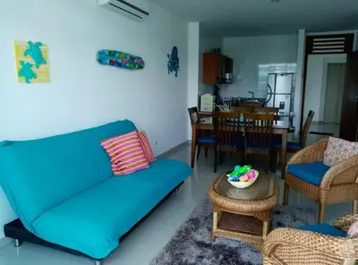 a living room with a blue couch and a table at Costa Azul Suites 1002 in Santa Marta